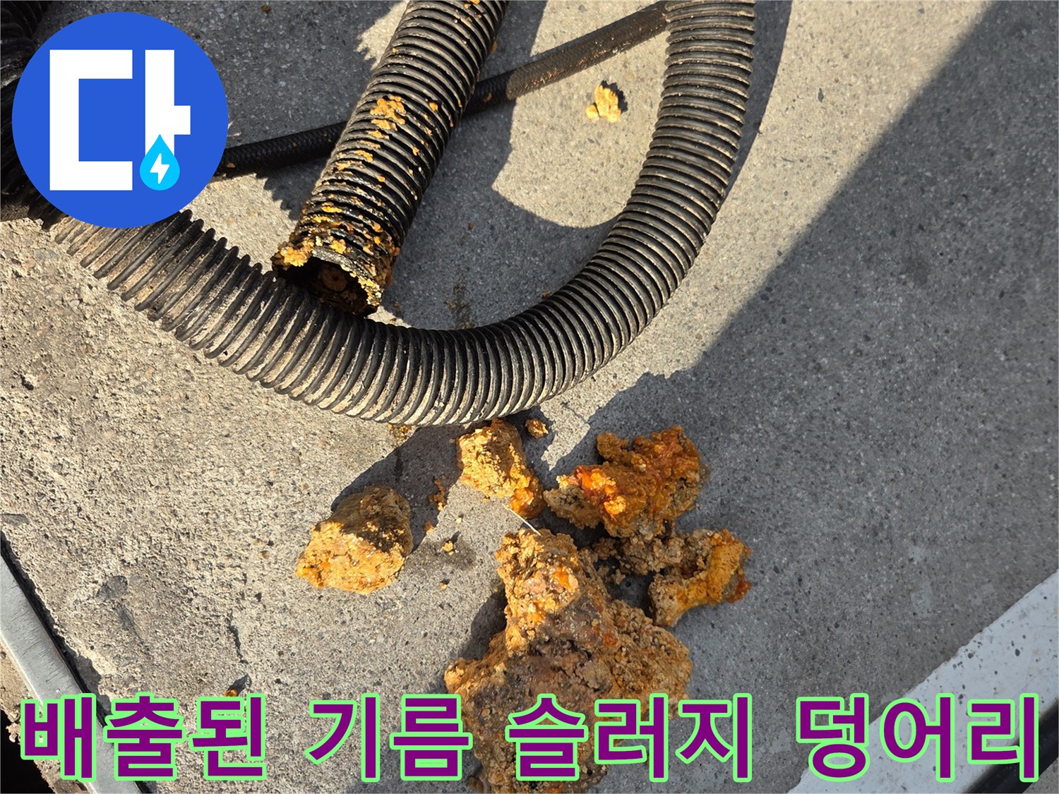 바닥에 놓인 노란색 기름 슬러지와 세척용 호스 장비