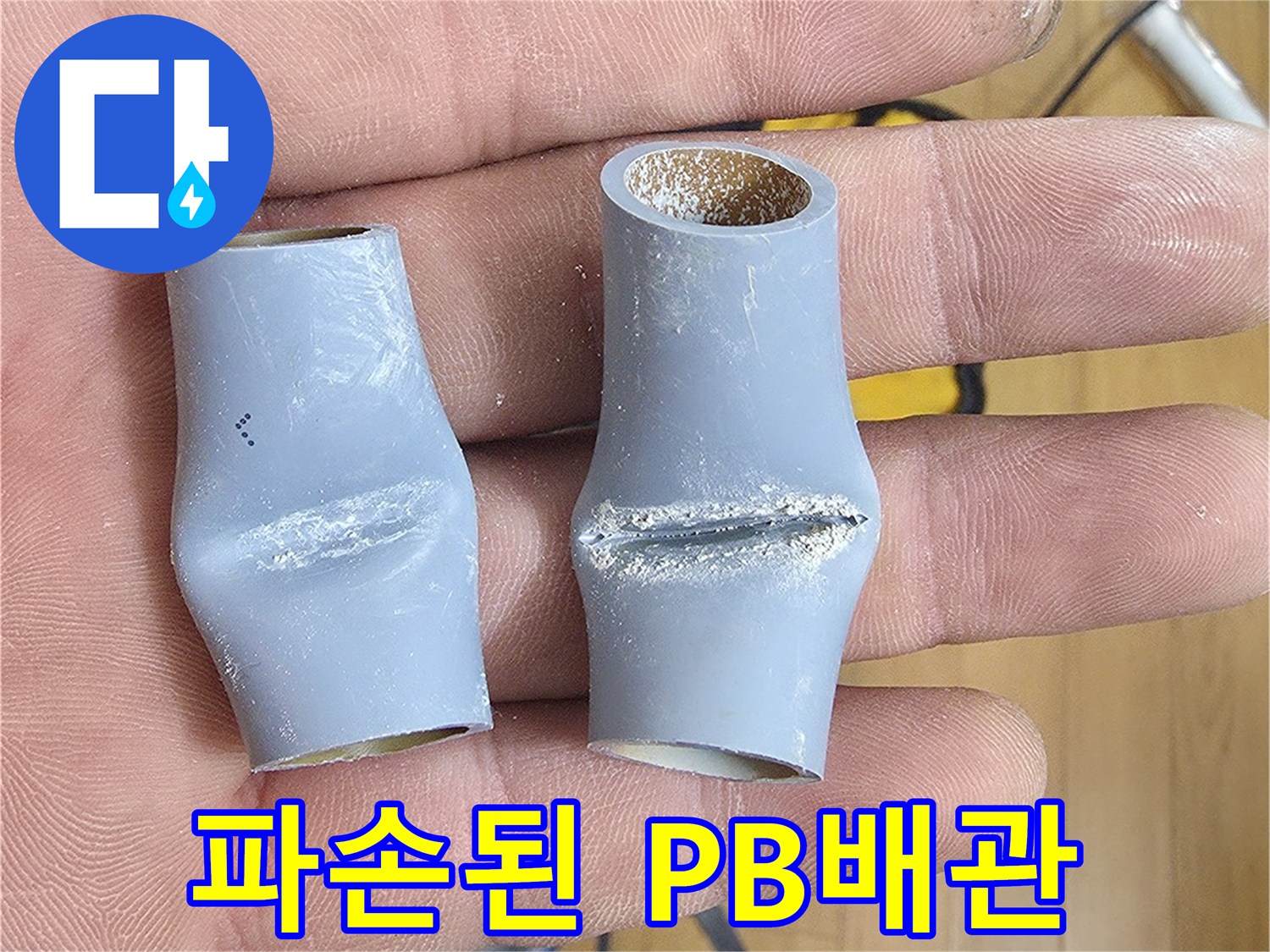 손에 들린-파손되어 함몰된-회색 PB배관 부속