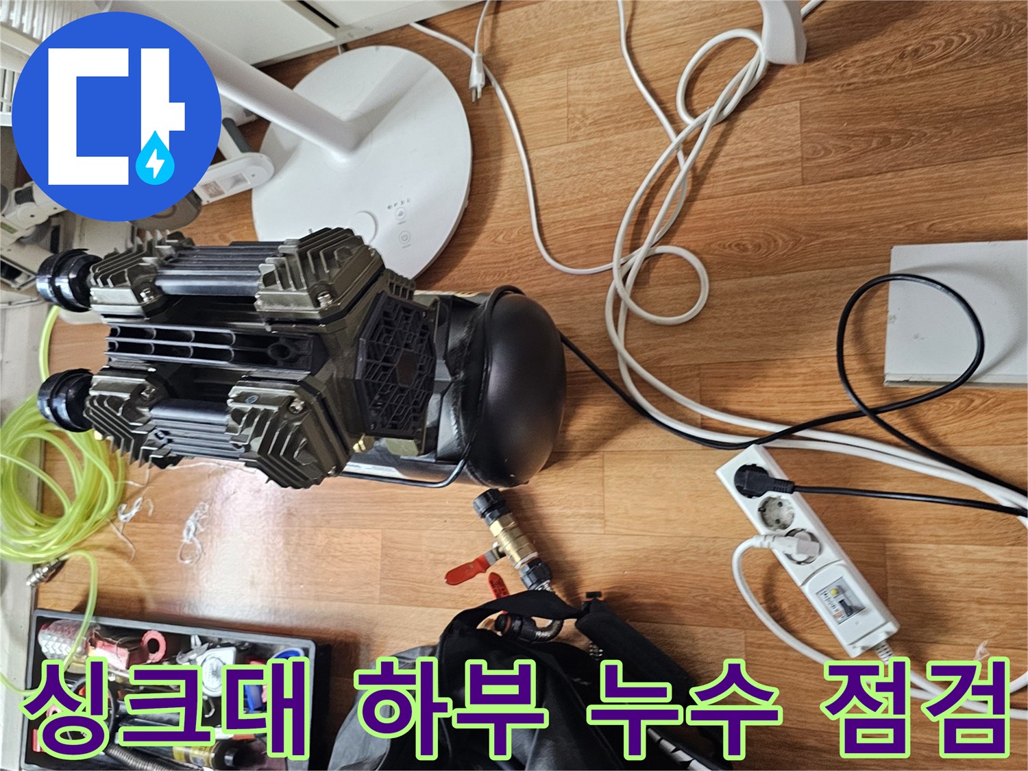 싱크대 하부장 주변의 배관 압력 테스트 장비와 공구 세팅 모습