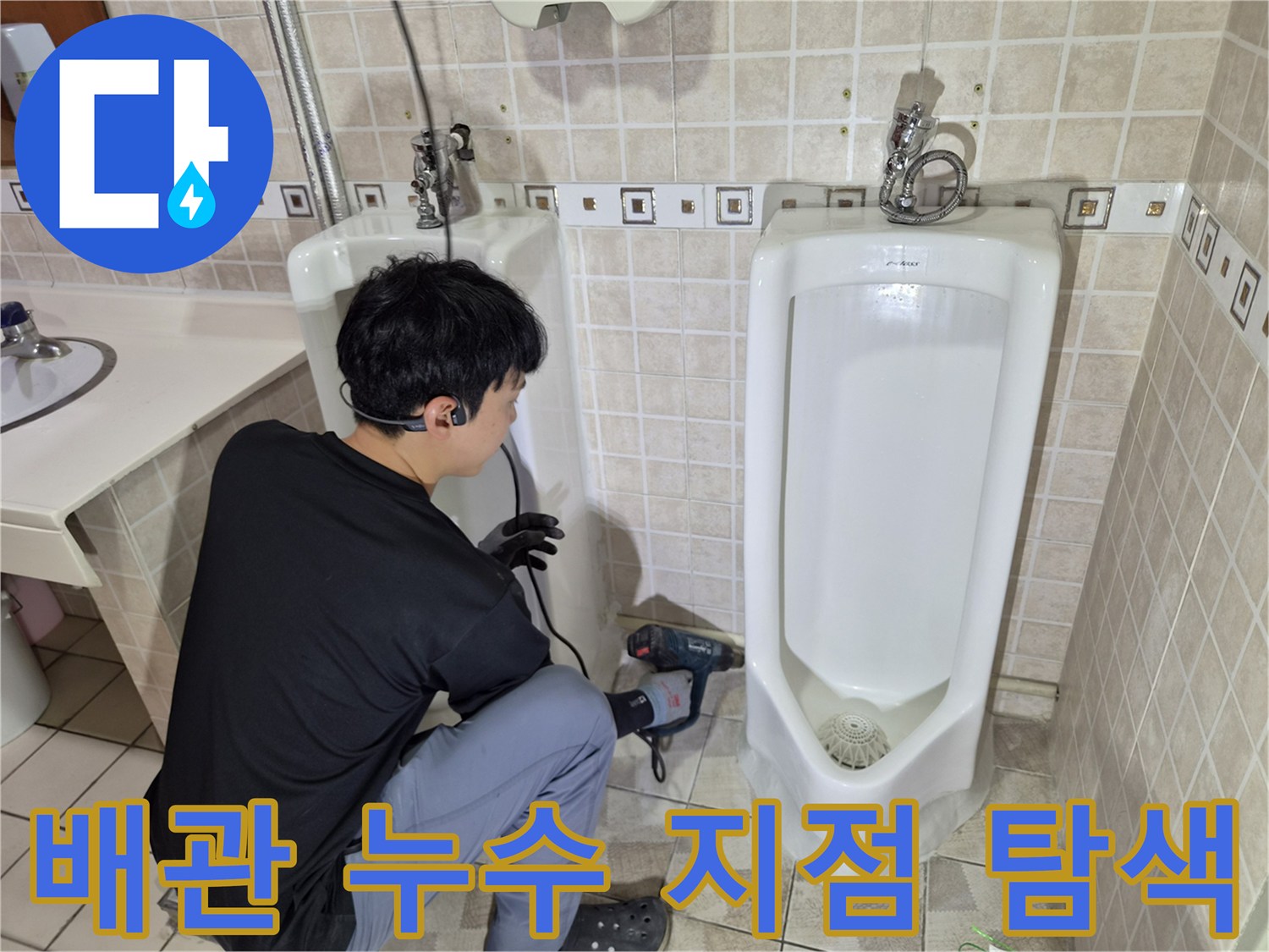 소변기 아래쪽 배관의 결함을 찾기 위해 작업 중인 엔지니어