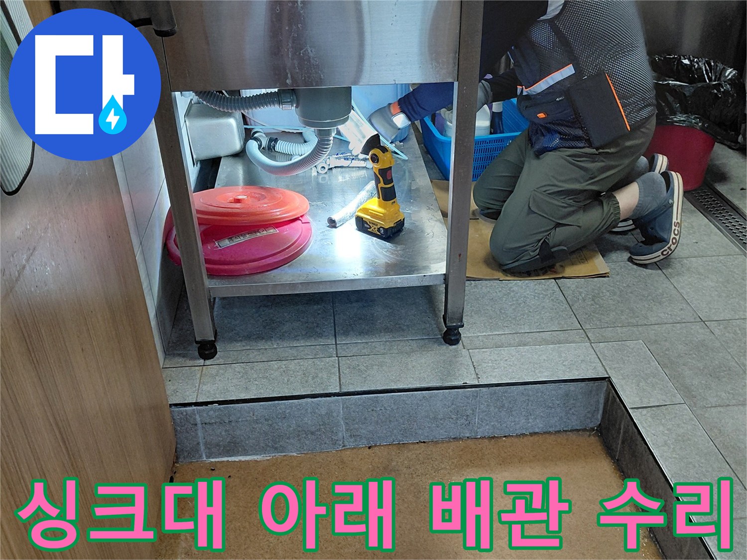 싱크대 하부장 내부의 에이콘 배관과 작업 도구들