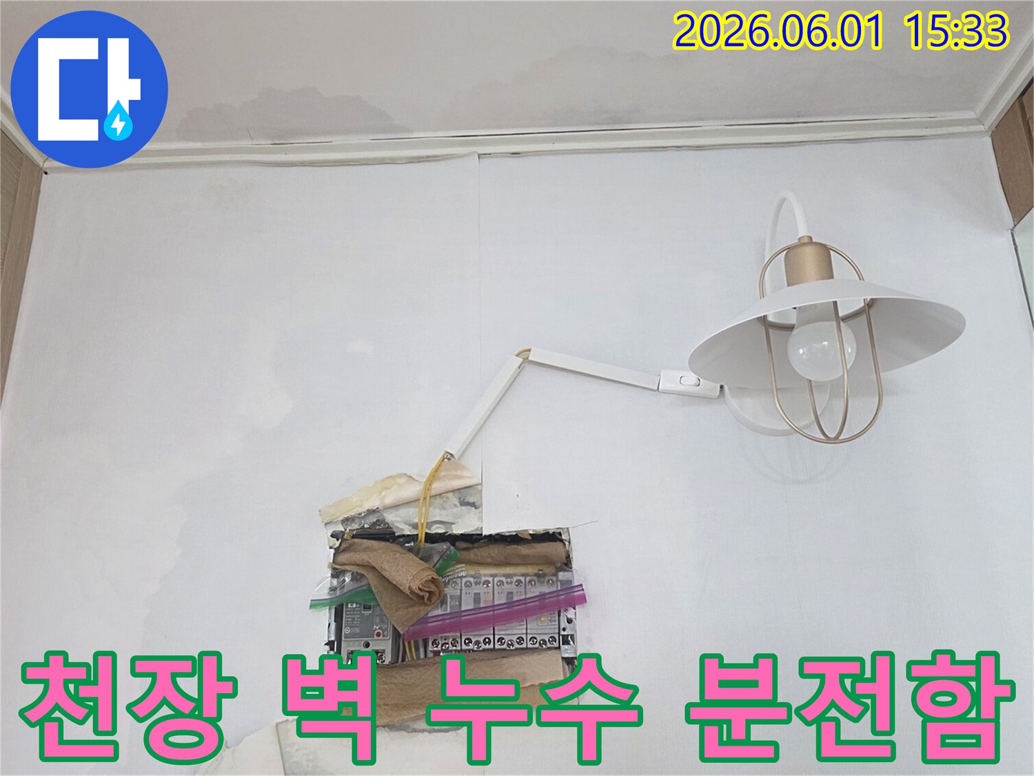 천장과 벽에 물자국이 선명하며-분전함 주변으로 물이 스며들어 전기 안전에 대한 우려가 큰 현장 모습입니다