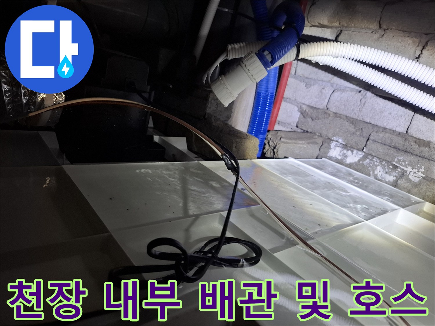 천장 안쪽의 흰색 주름관과 파란색 호스-배관 점검 작업