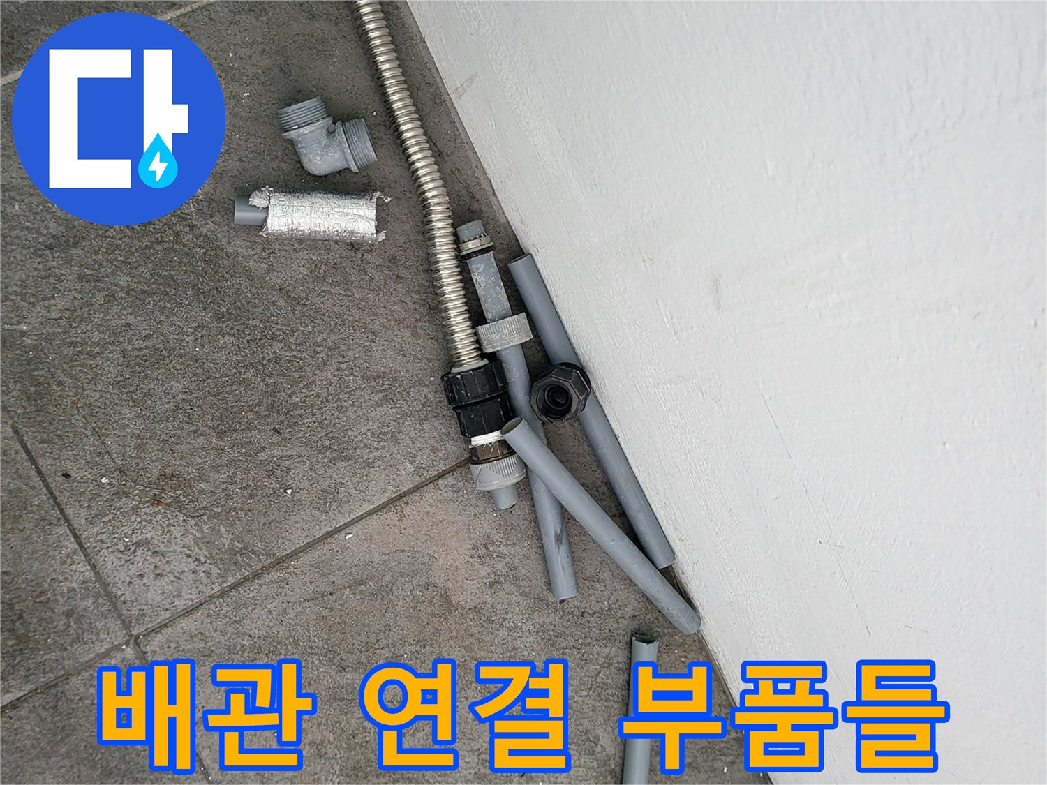 현장 바닥에 놓인 회색 배관과 은색 주름관 자재
