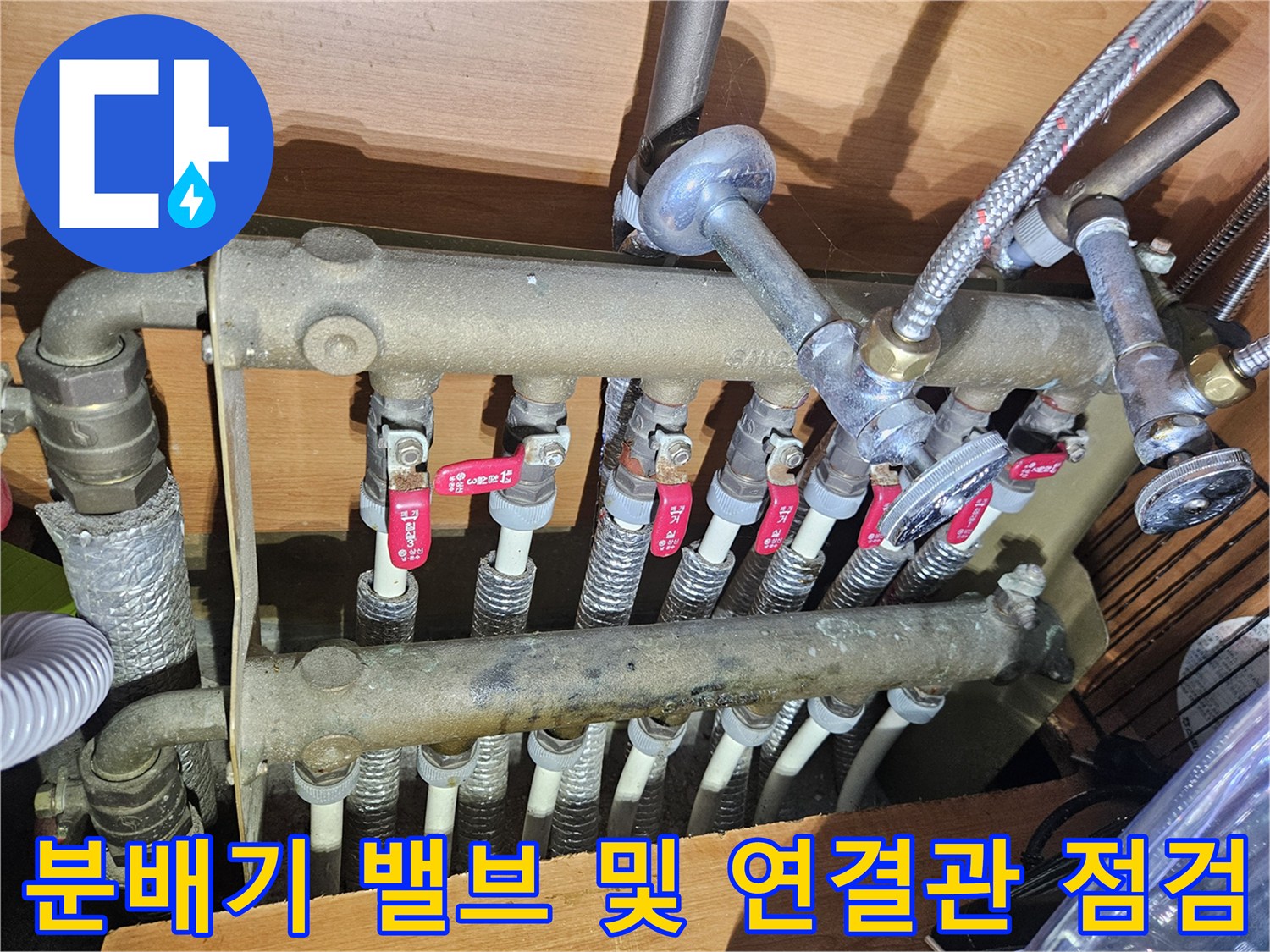 빨간색 밸브가 달린 금속 분배기 배관 구조
