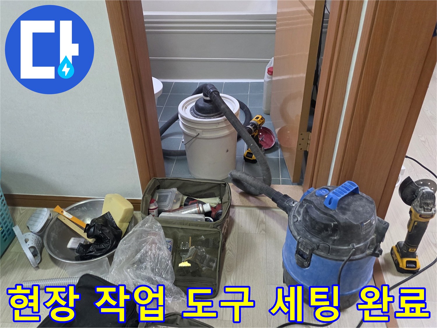 바닥에 놓인 산업용 청소기와 수리용 공구들
