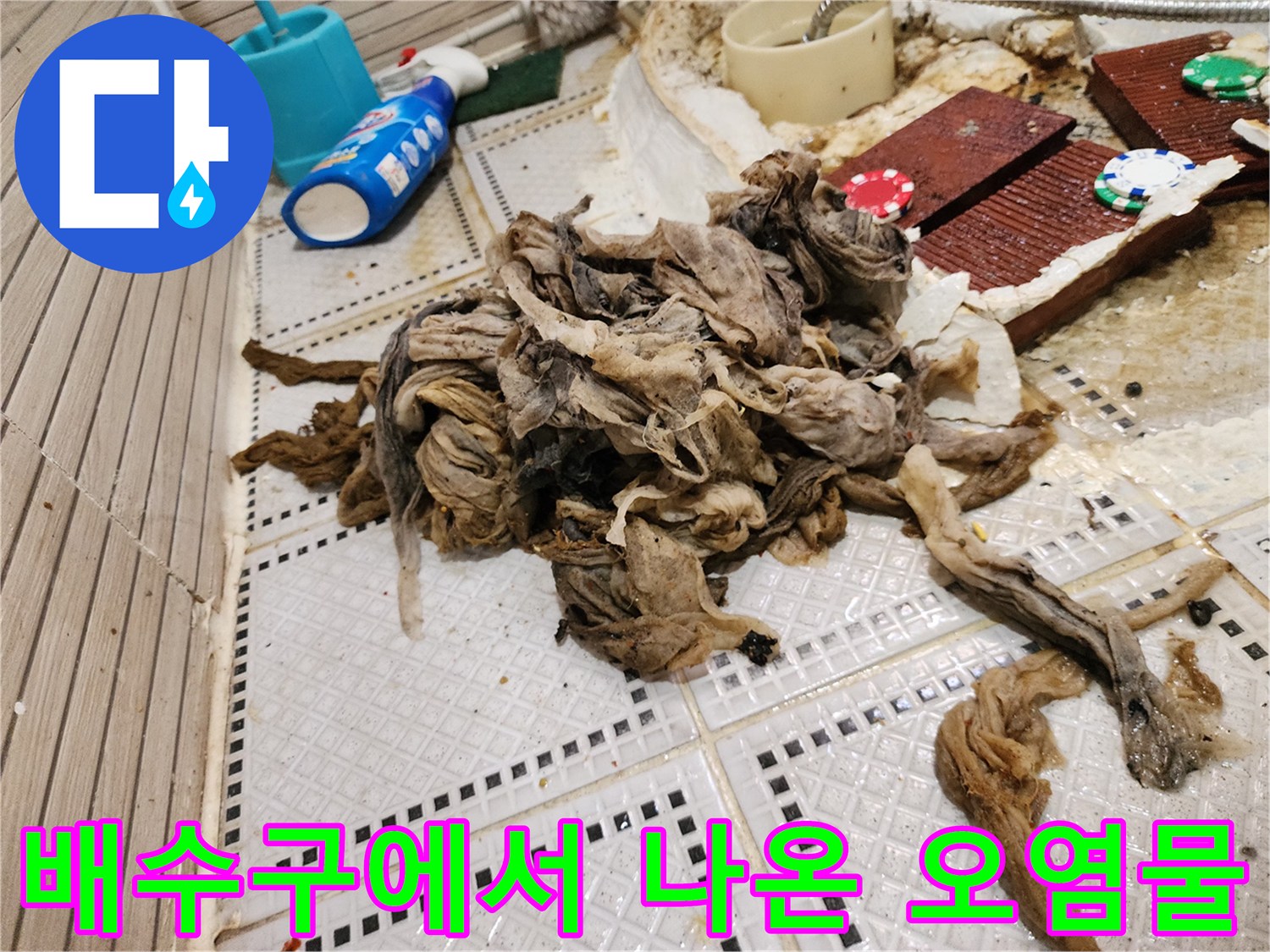 타일 위에 놓인 머리카락과 섬유질이 뒤엉킨 커다란 슬러지 덩어리
