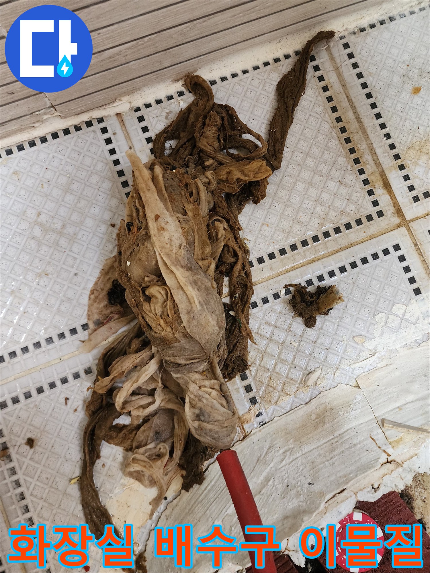 화장실 타일 바닥에 드러난 거대한 머리카락과 섬유 찌꺼기 덩어리