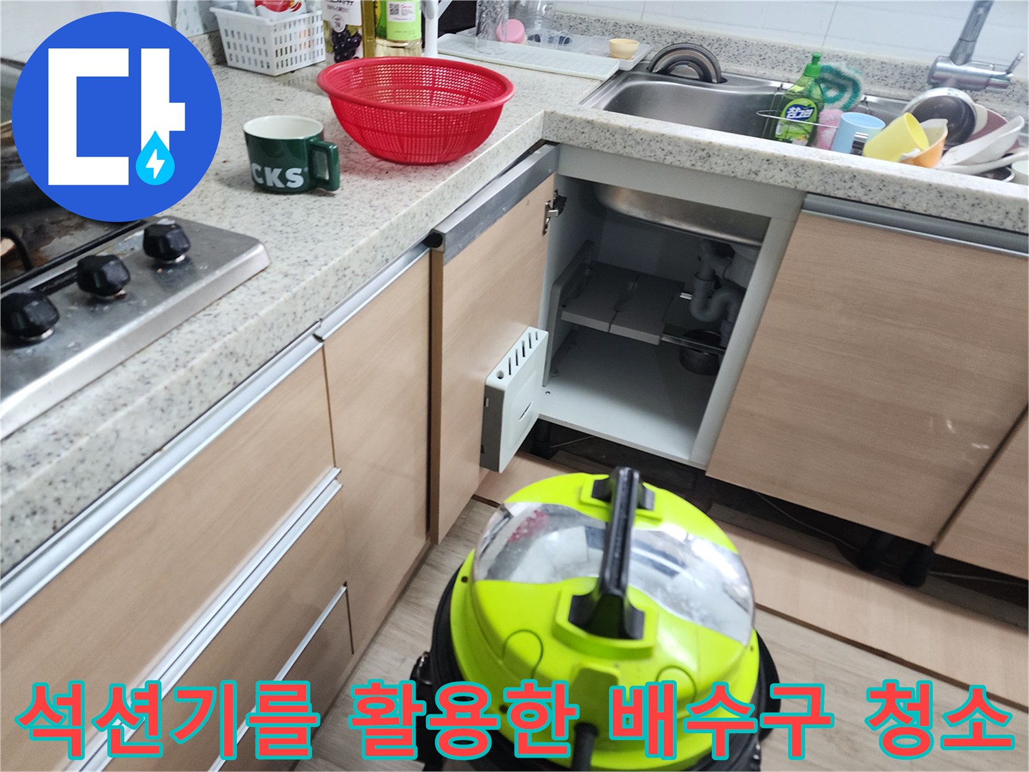 싱크대 하부장 내부에 설치된 노란색 석션 장비와 배수 관로