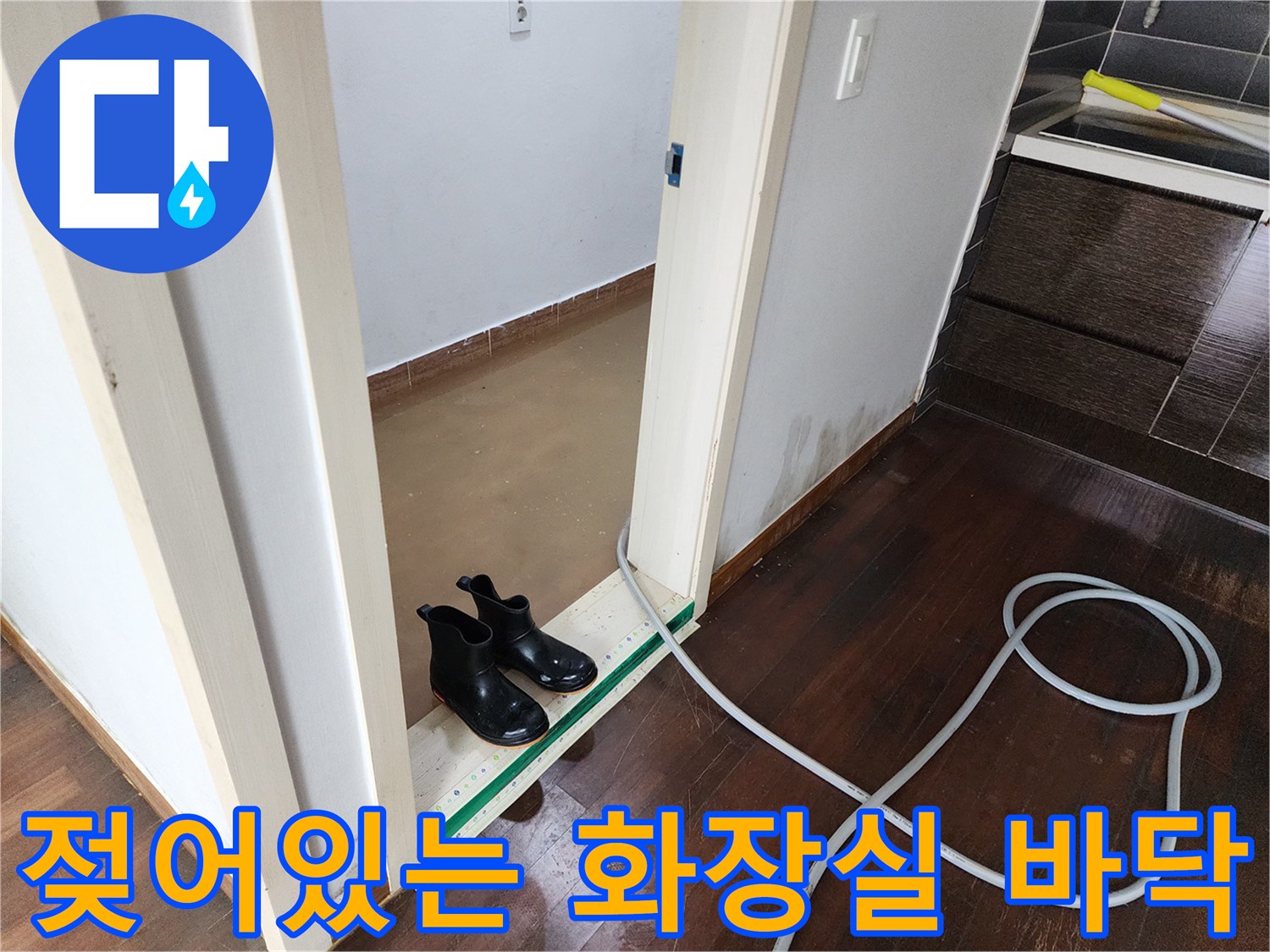 물기가 남아있는 화장실 입구와 배수 호스 배치