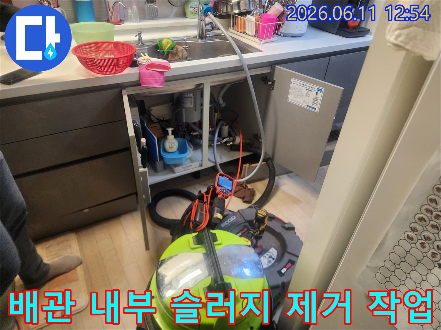 싱크대 하단 배관 청소를 위해 사용 중인 석션기와 스케일링 장비