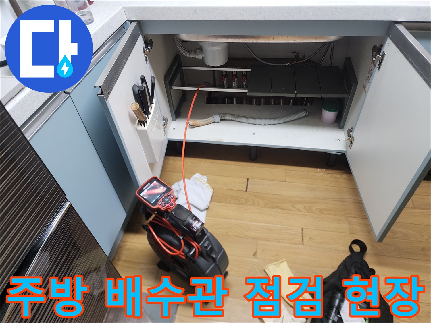 중곡동 주방-싱크대 하단부의 배수 호스와 작업용 석션기 모습