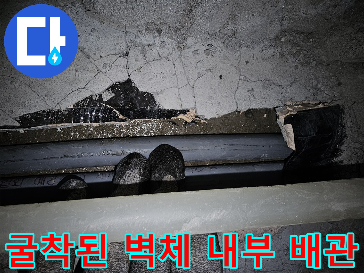 벽면 틈새-노출된 배관과 균열된 콘크리트 구조물