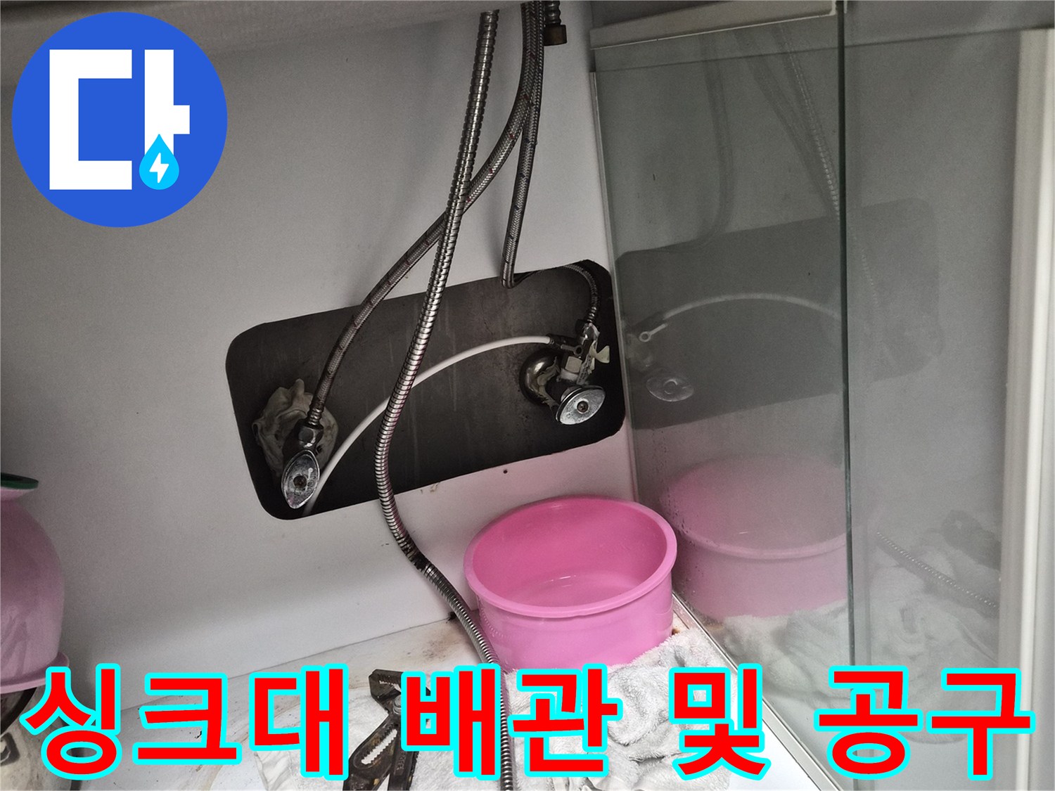 작업을 위해 준비된 펜치와 싱크대 하부 배관의 모습