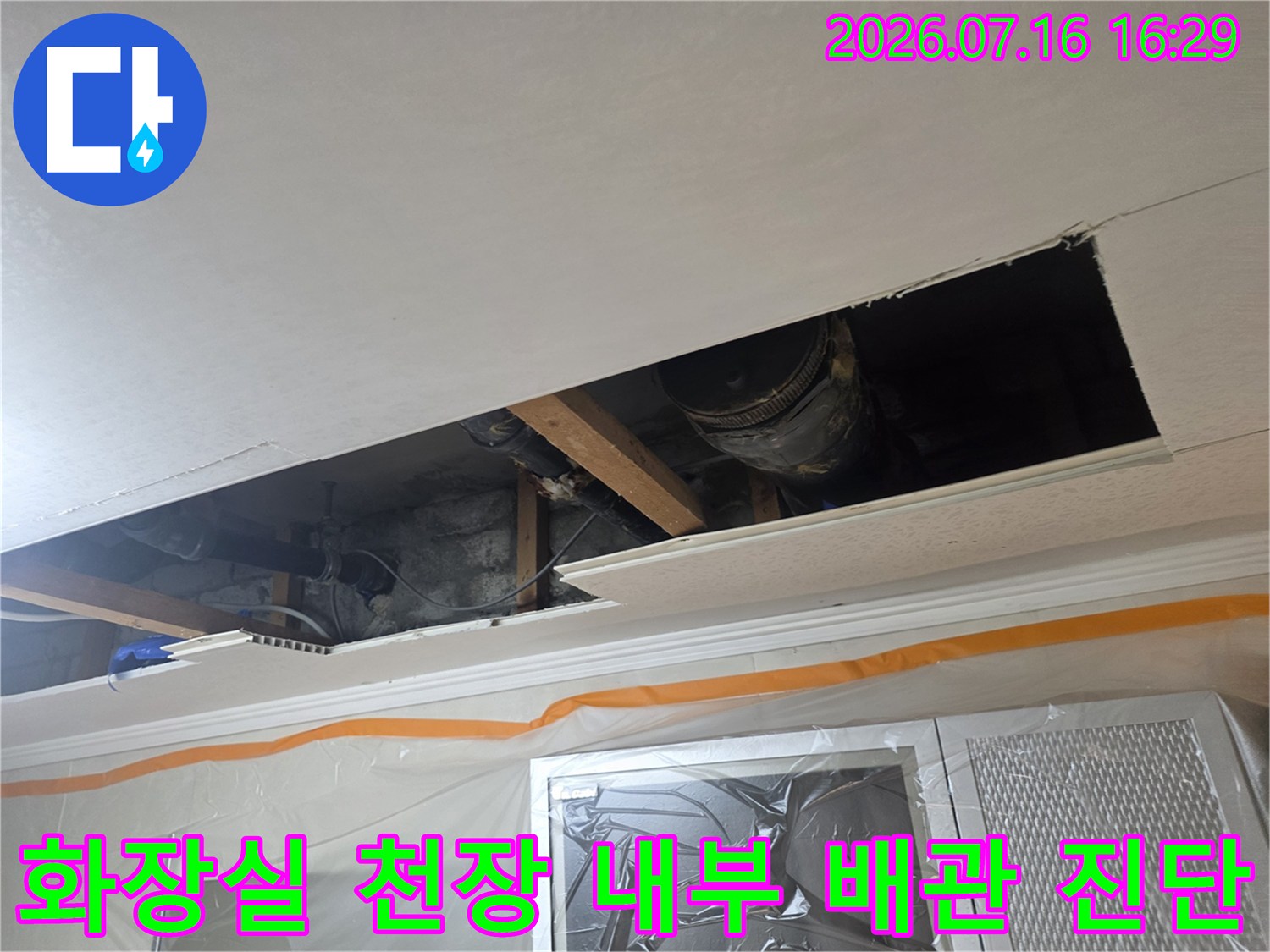 천장 점검구 안쪽의 여러 배관 구조를 확인하며 누수 지점을 찾는 모습
