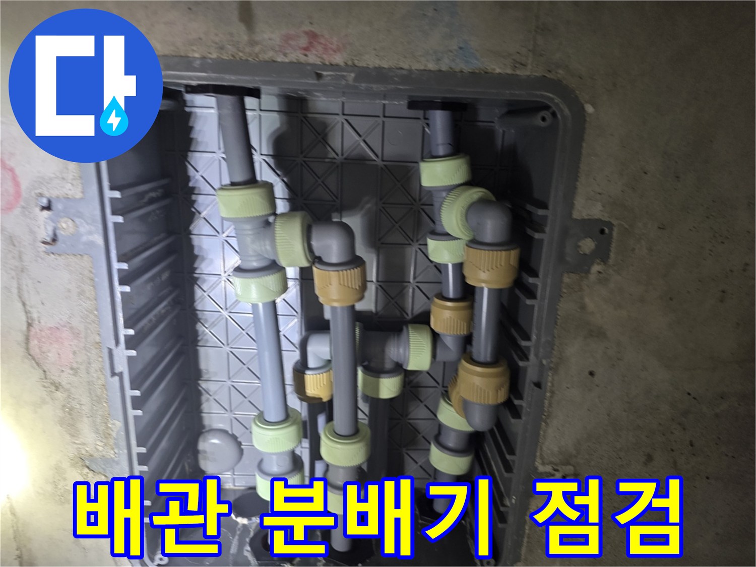 복잡하게 얽힌 회색 수도 배관과 연결 부속의 상세 사진입니다.