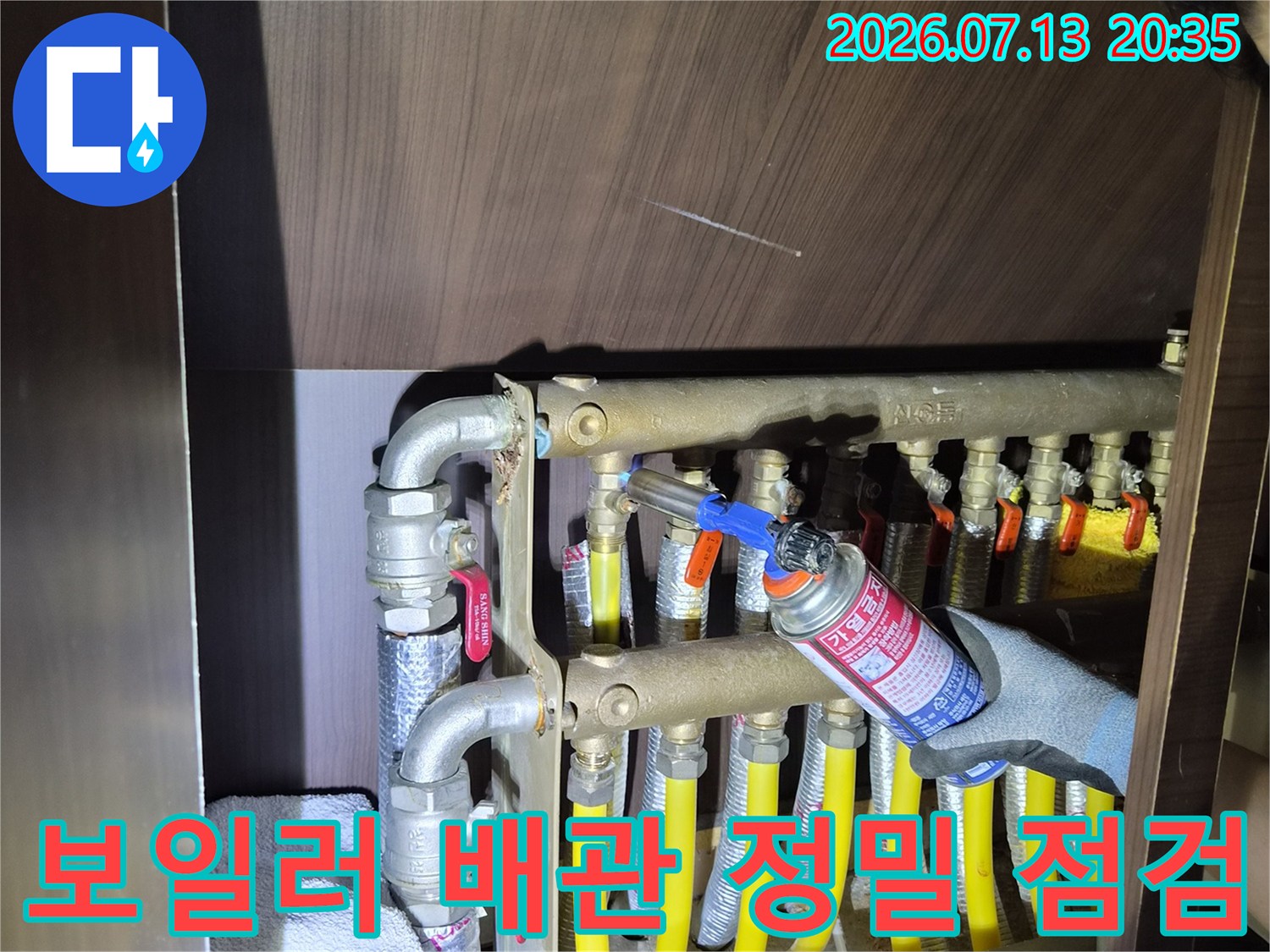 보일러실 내 노란색 보온재로 감싸진 배관과 분배기 연결 부위 점검 모습