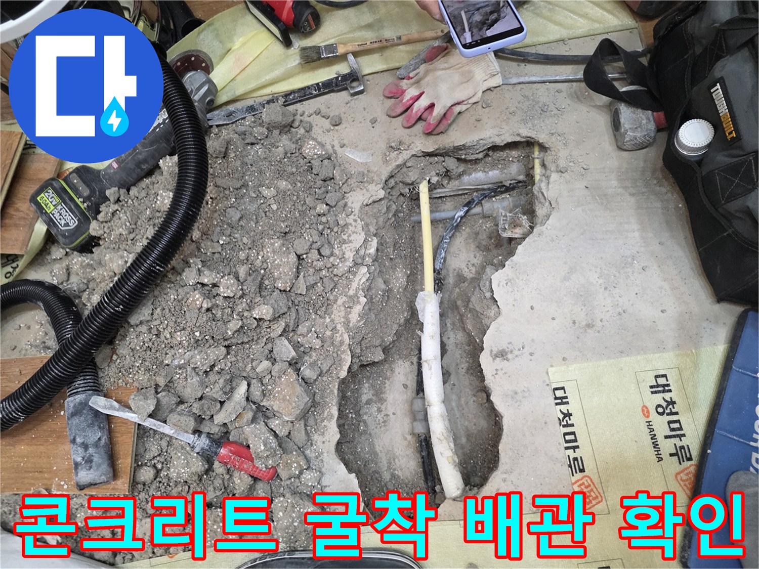콘크리트 파쇄 후 드러난 노출 배관과 작업 도구