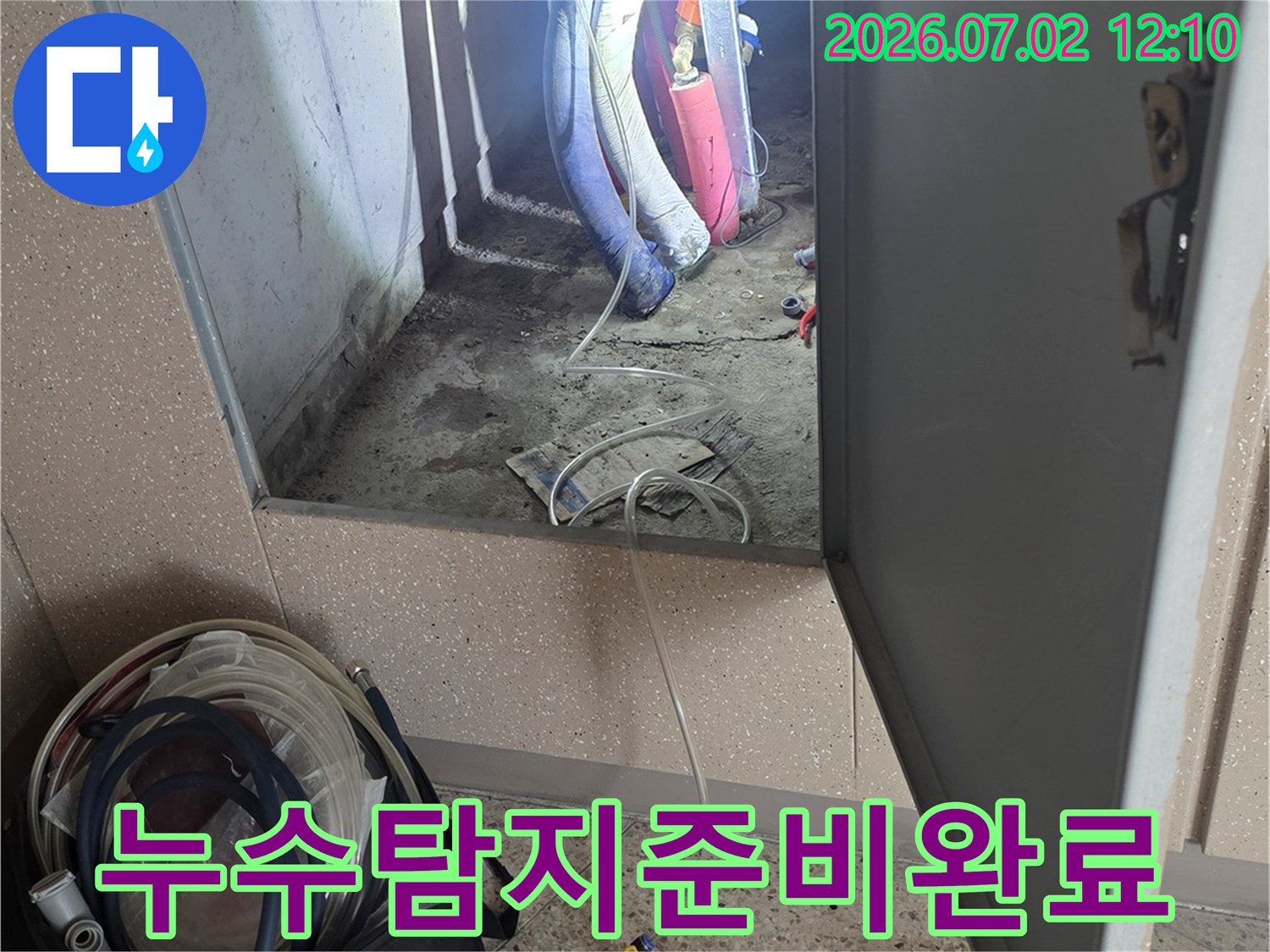 누수-탐지-전문가가-배관-점검구-옆에서-장비를-준비하고-있는-모습