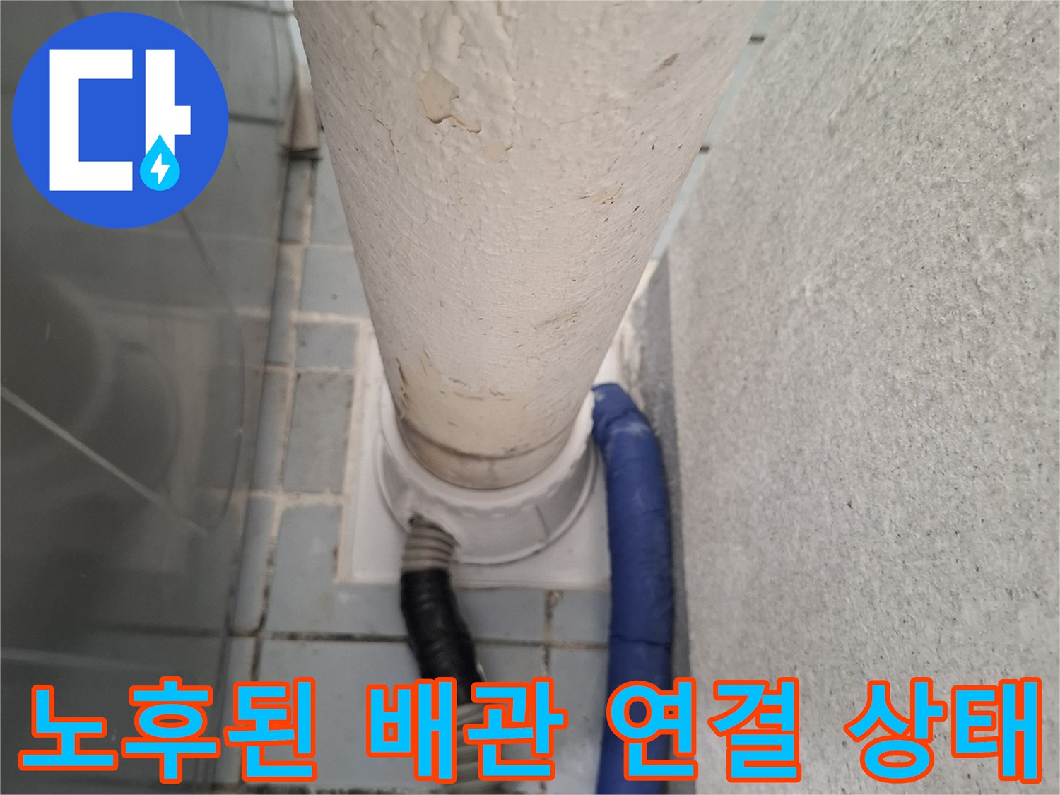 흰색 수직 관과 파란색 호스의 접합부 근접 촬영