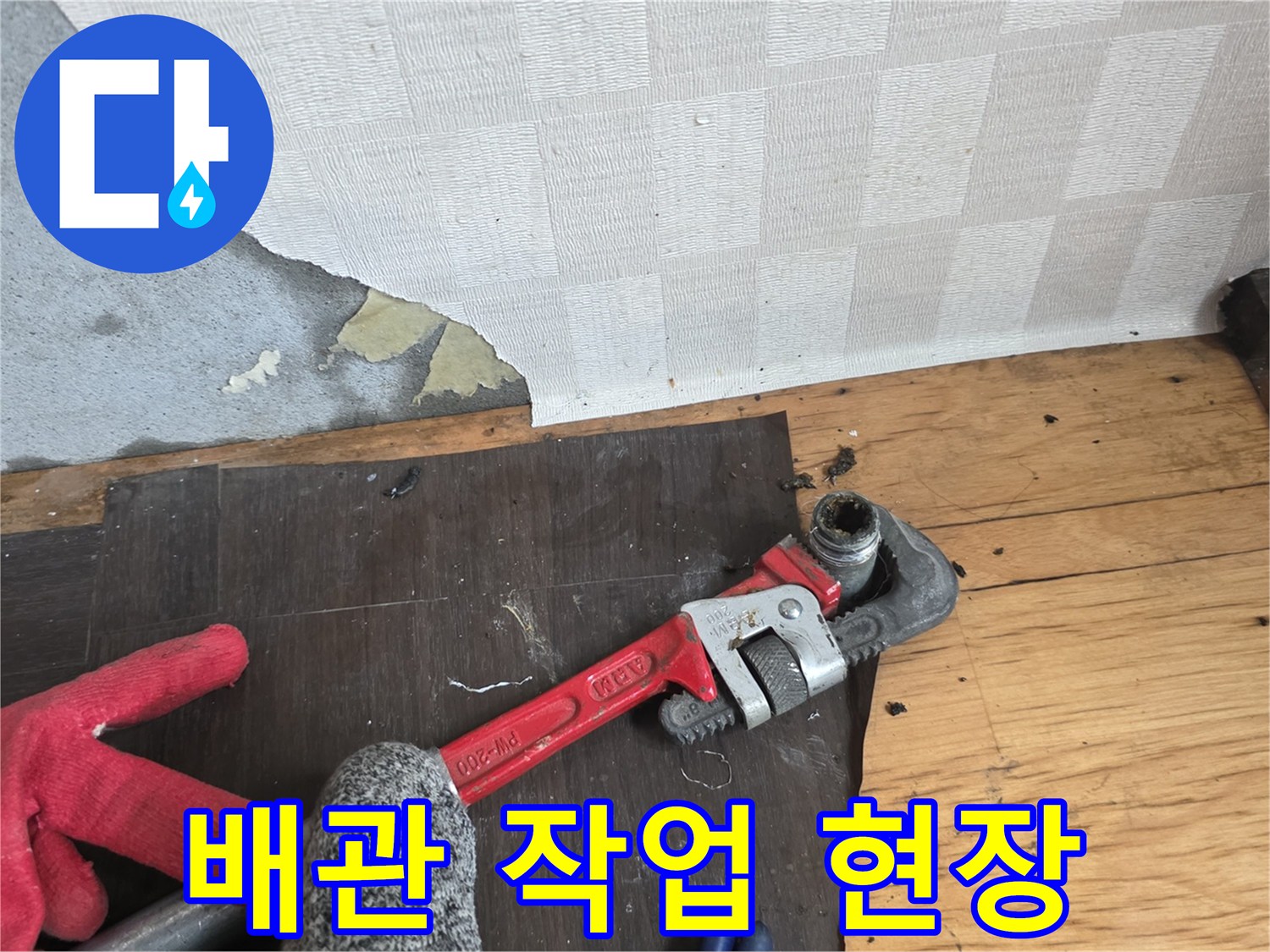 파이프렌치-와-작업용-장갑-및-젖은-바닥