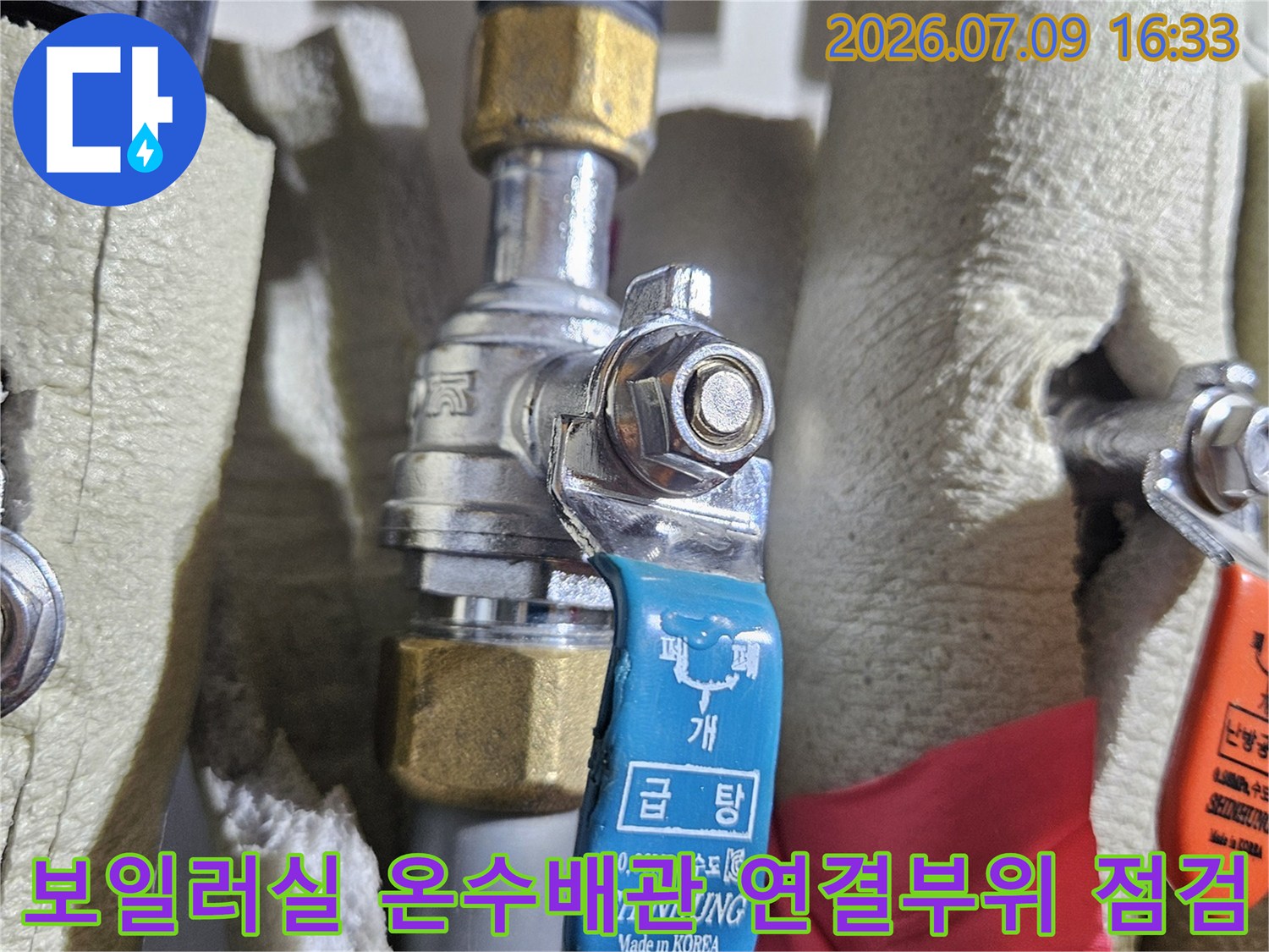 보일러실 내부에 설치된 파란색 밸브가 달린 온수 배관 상세 사진