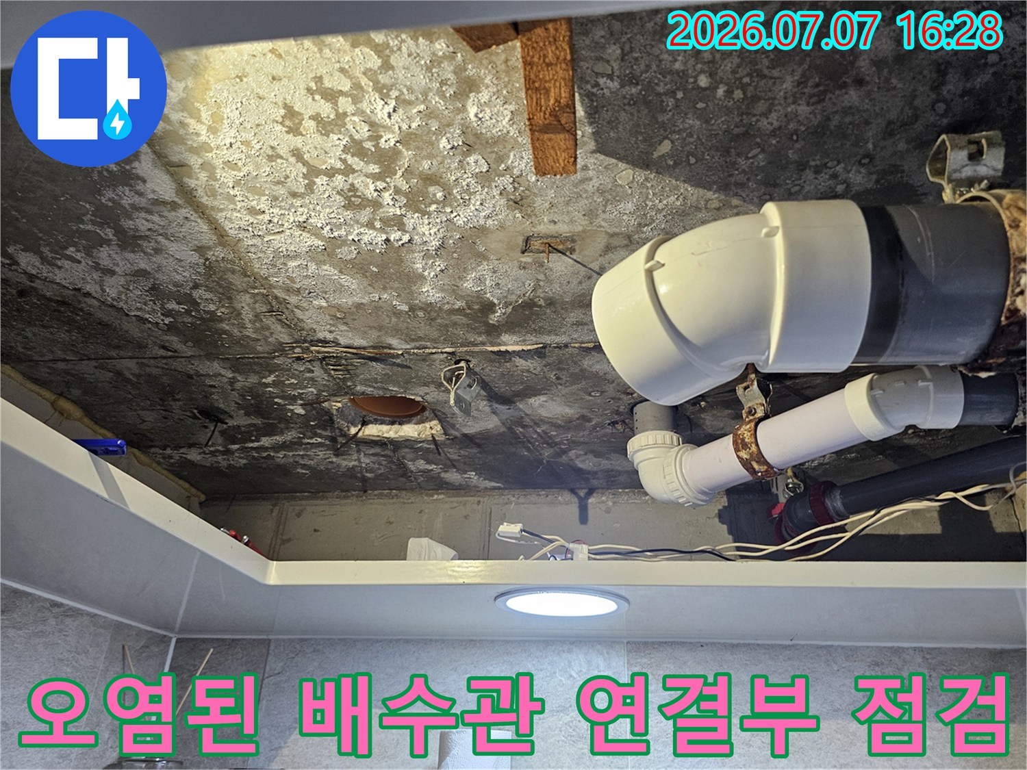 화장실 천장 내부의 노후한 배수 배관과 오염된 부속을 촬영한 사진