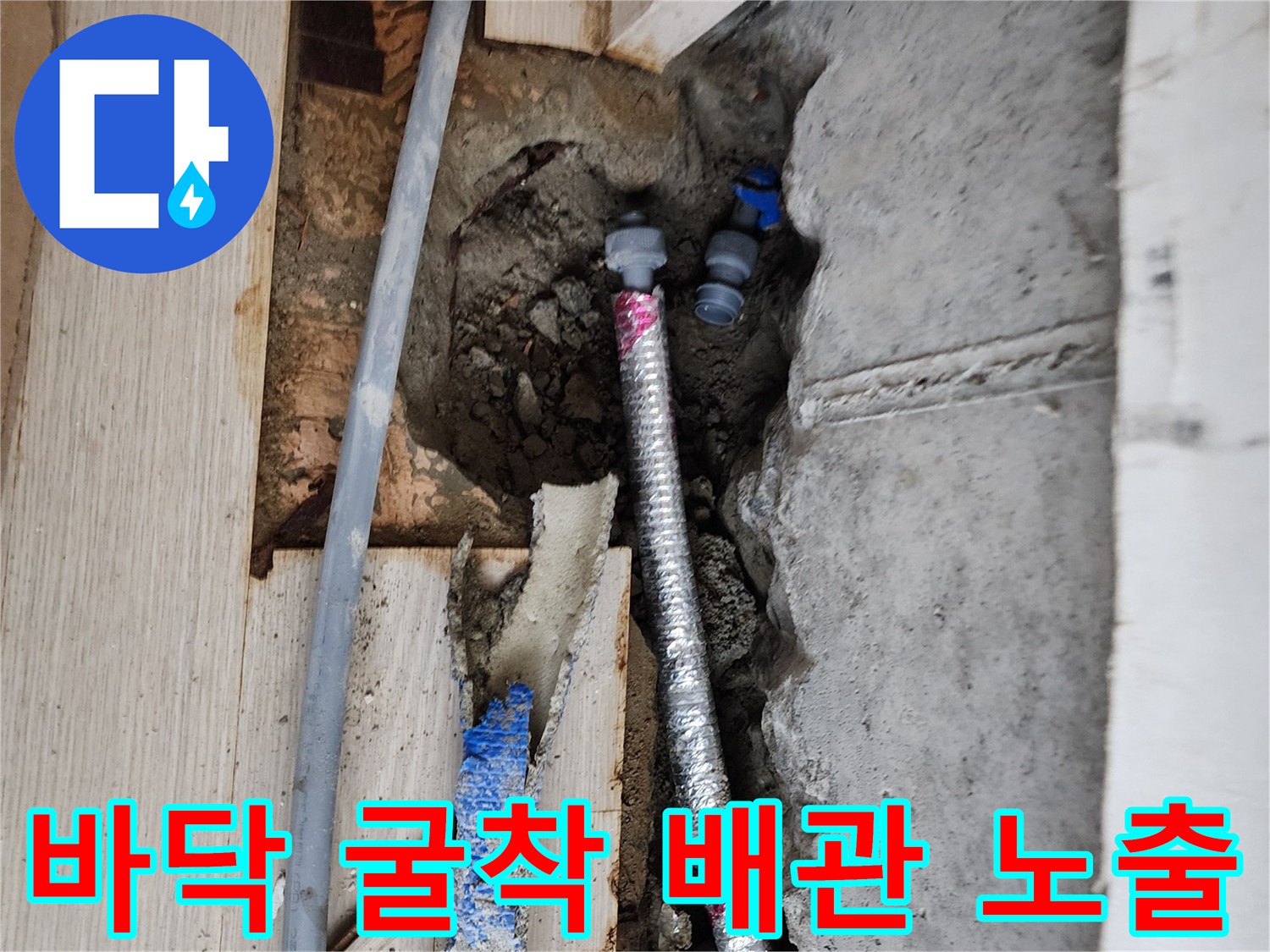 시멘트를 제거하여 드러난 은색 주름관과 파란색 배관의 정밀 점검 장면