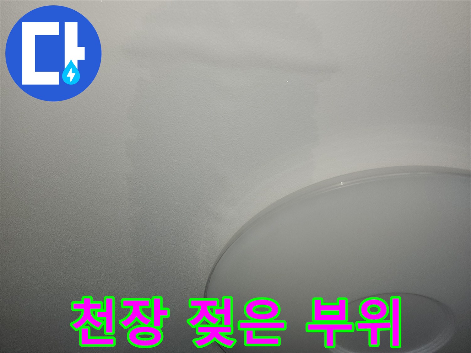 조명 아래 넓게 퍼진 천장 누수 얼룩