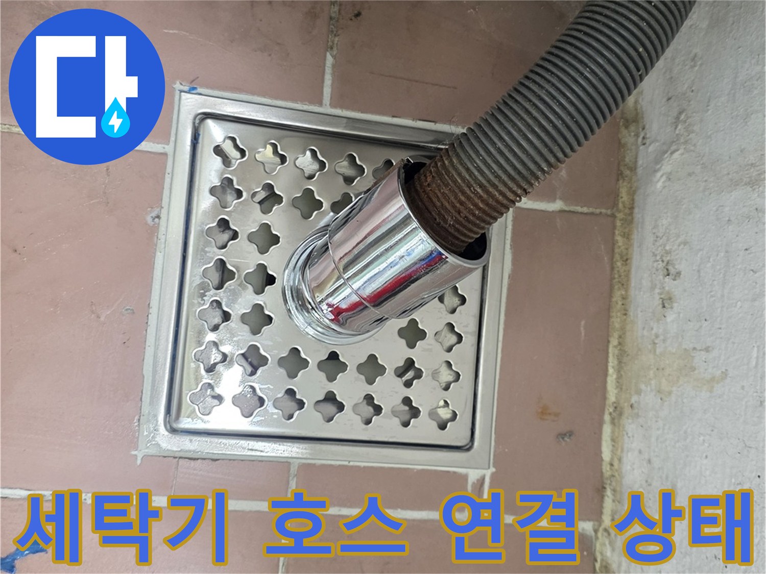 배수 호스가 꽂혀 있는 스테인리스 배수 트랩