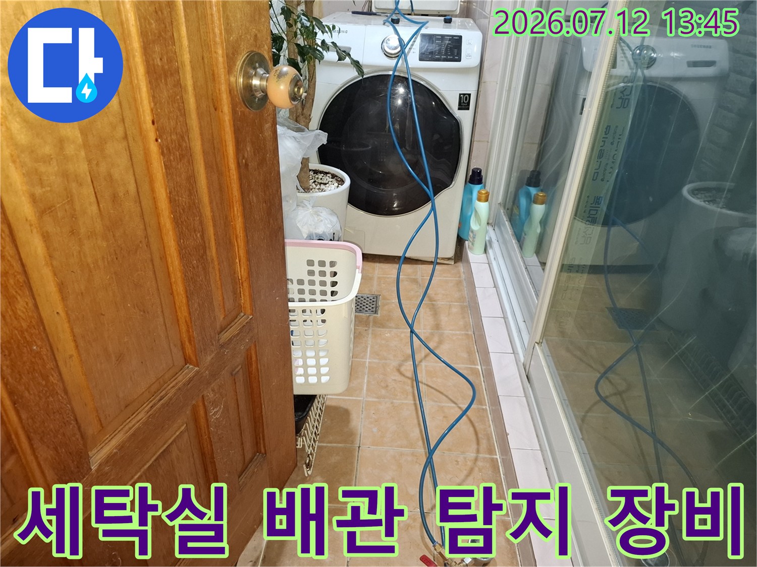 파란색 테스트 호스가 연결된 세탁기 옆 누수 점검 현장 사진