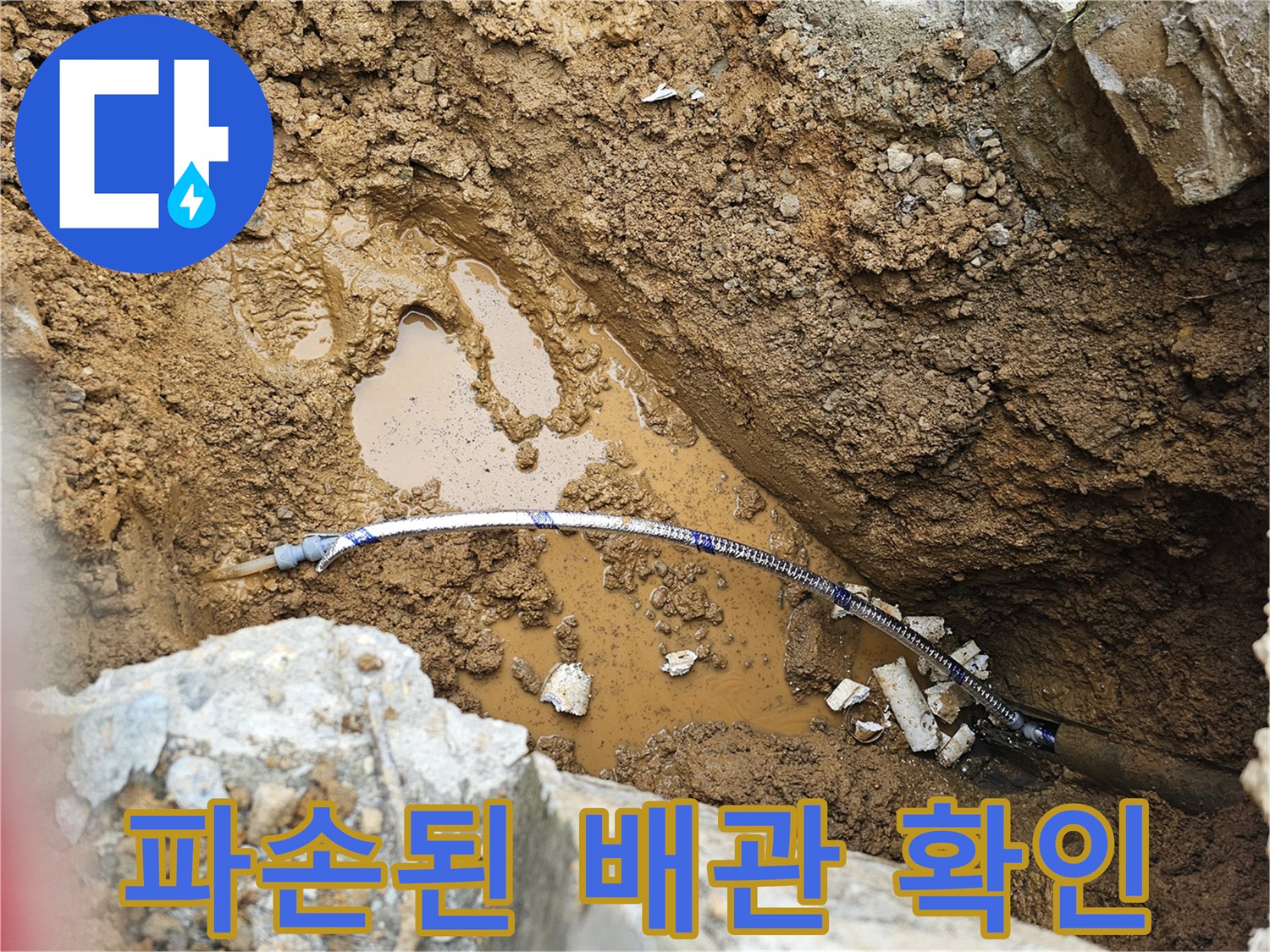 축축하게 젖은 흙 속에 드러난 수도 배관 부위