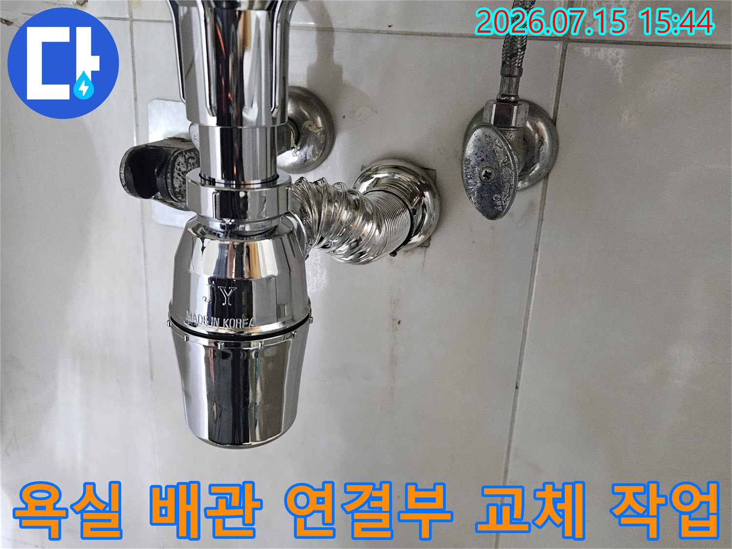 금속 재질의 세면대 하부 배관과 굴곡진 파이프가 연결된 모습