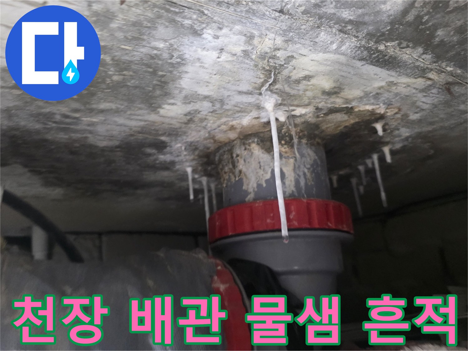 배수 파이프 주변에 넓게 퍼진 젖은 자국과 석회 침착물
