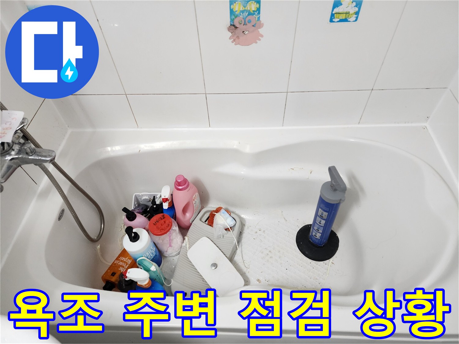 욕실 욕조 내부에 놓인 세정제와 실리콘 작업 도구