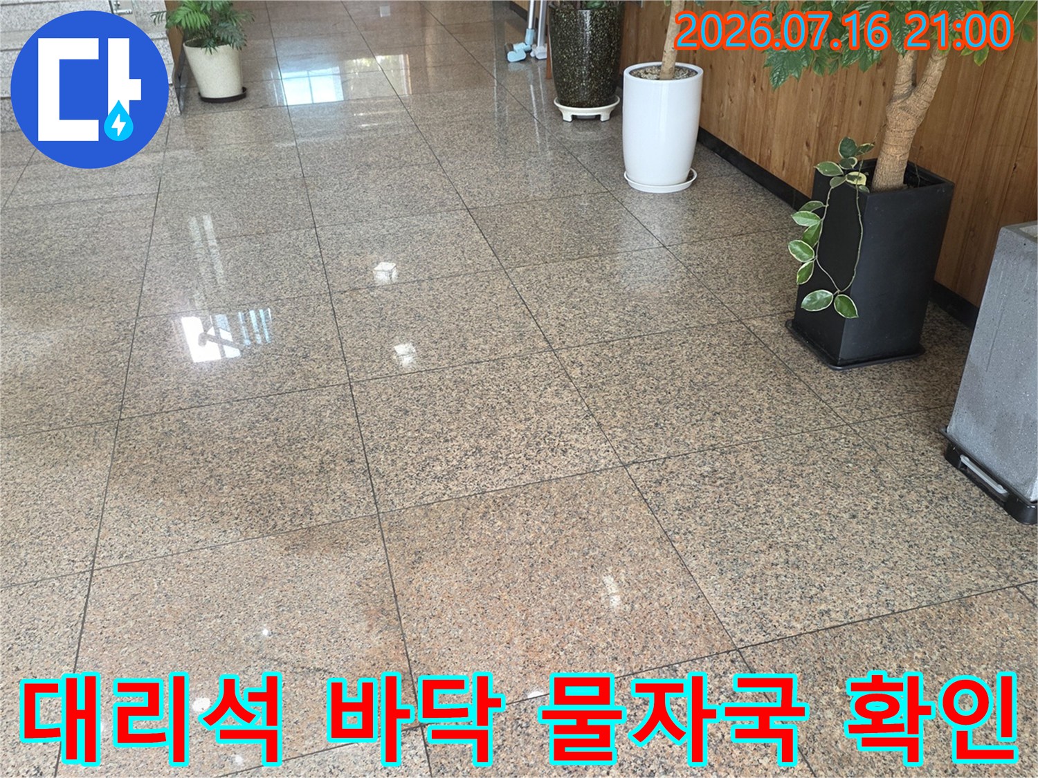 로비 대리석 타일 위 누수 흔적과 건물 외관 구조물