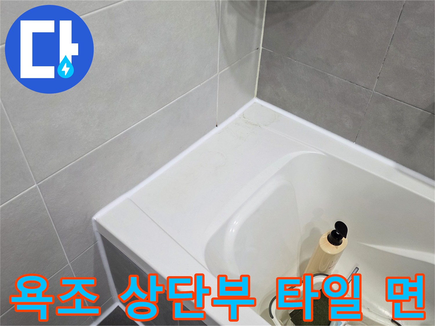 밝은 색상의 욕조와 차분한 회색 타일 벽면