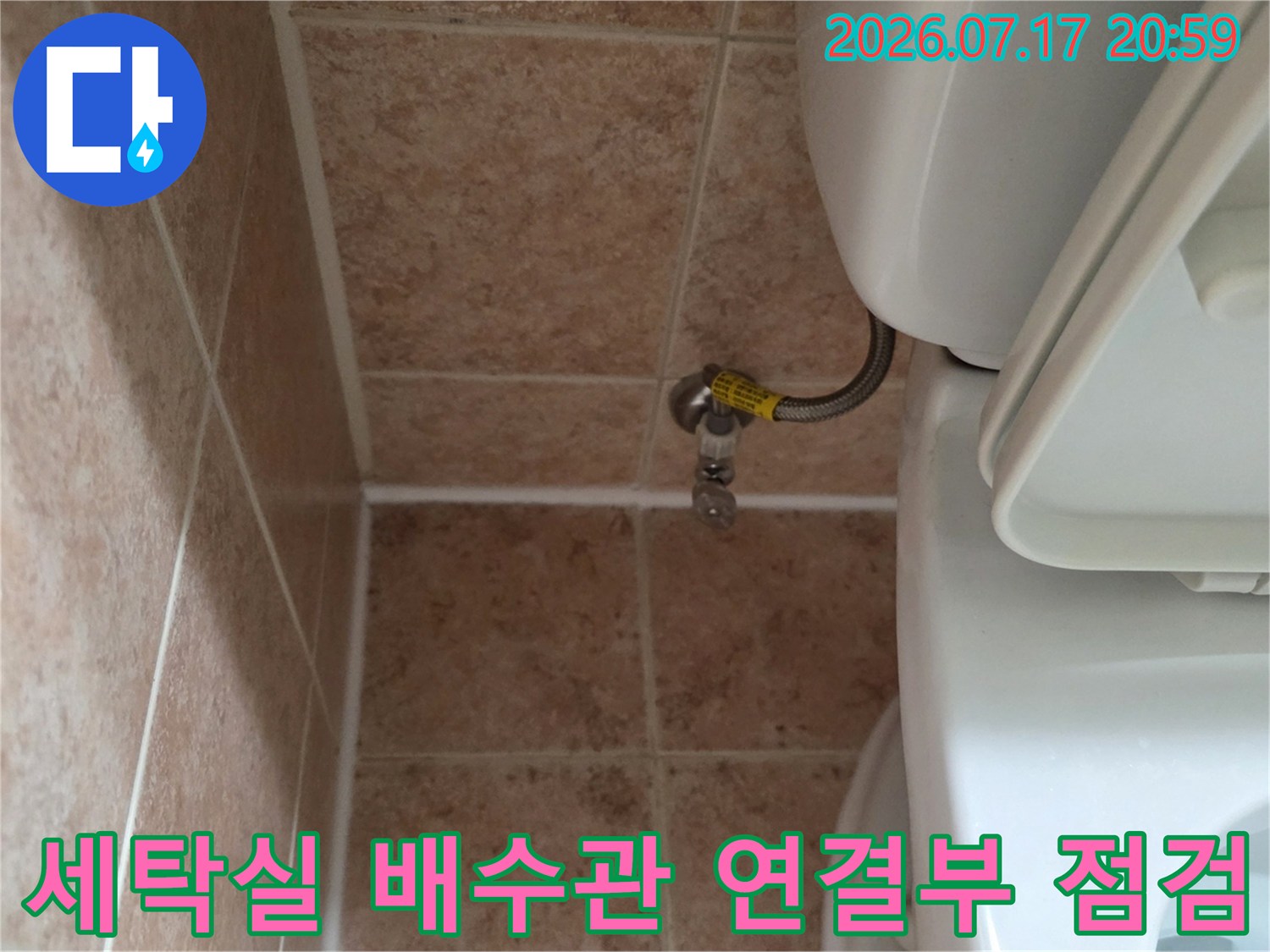 세탁기 배수용으로 연결된 배관과 밸브가 설치된 세탁실 내부 모습