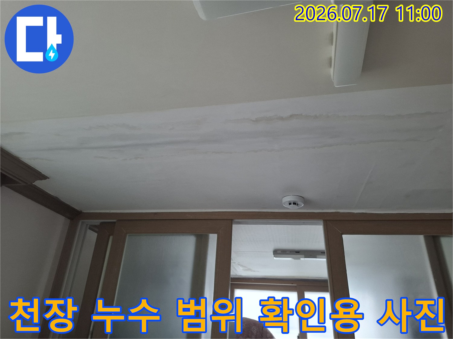 천장 마감재에 스며든 물자국과 설치된 화재 감지기 모습