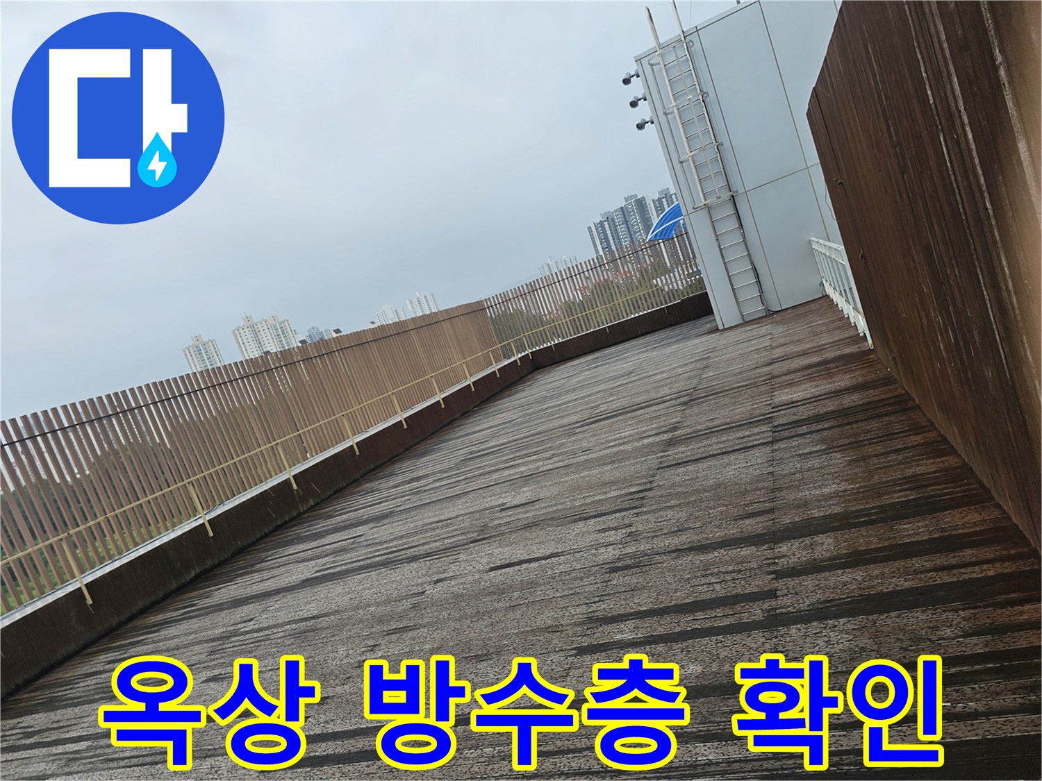 물기가 가득한 옥상 바닥 마감재와 난간의 모습