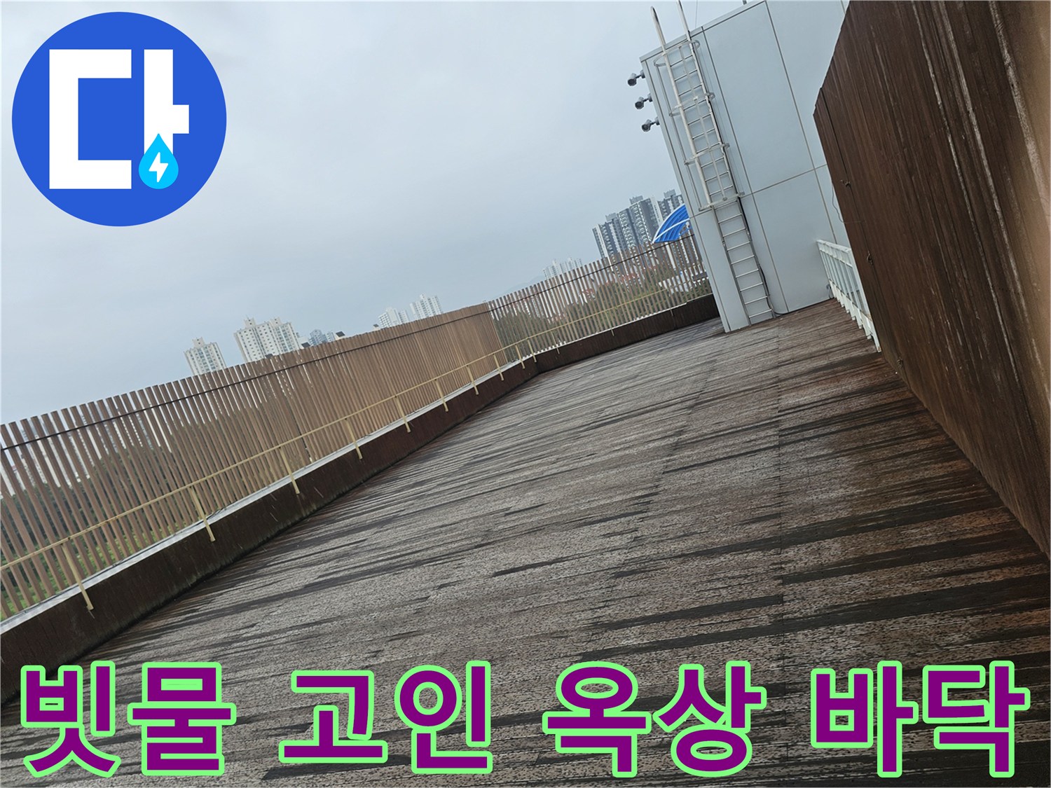 비에 젖어 물이 고여 있는 옥상 구조물 및 난간 부위