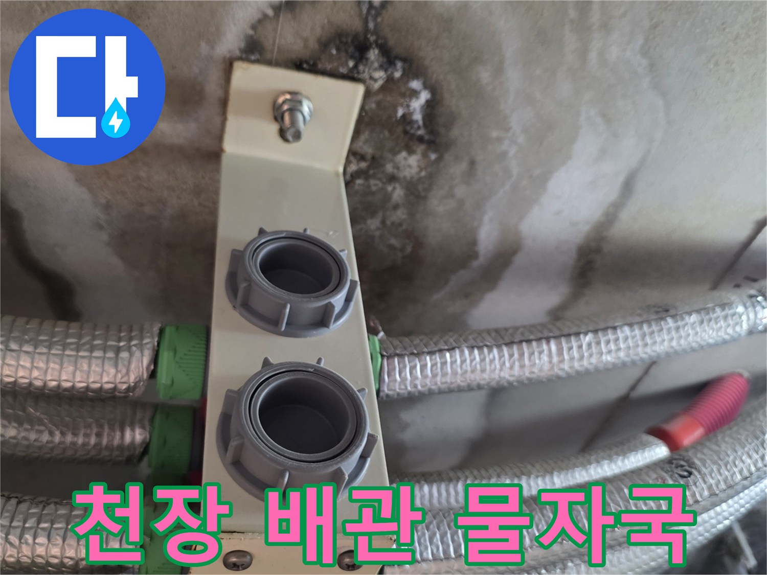 천장 배관 상단의 젖은 얼룩과 습기 침투 흔적