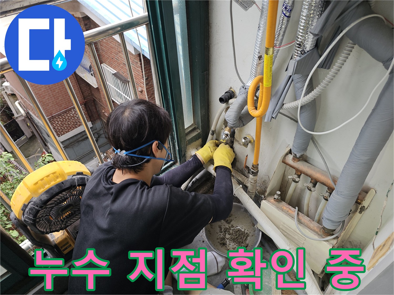 작업자가 장갑을 끼고 노란색 배관의 연결 부위를 손으로 점검하는 장면