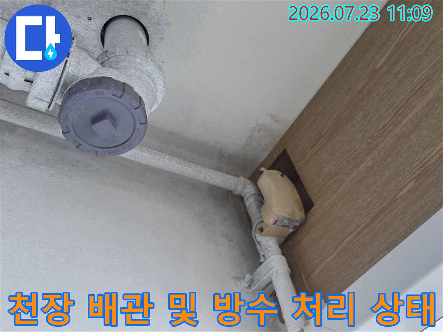 아파트 천장에 설치된 흰색 배관과 연결 부위의 방수 마감재-작업 모습