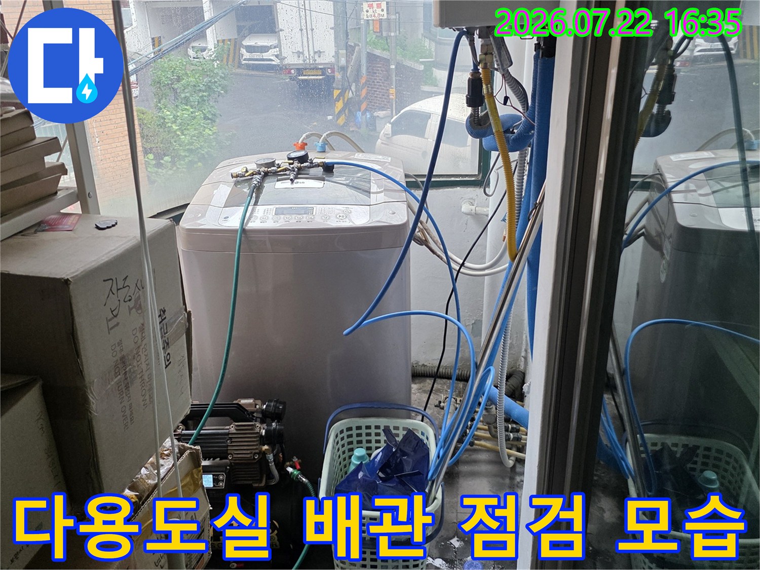 세탁실 내부에 설치된 흰색 가전제품과 연결된 푸른색 수도 배관-점검 과정
