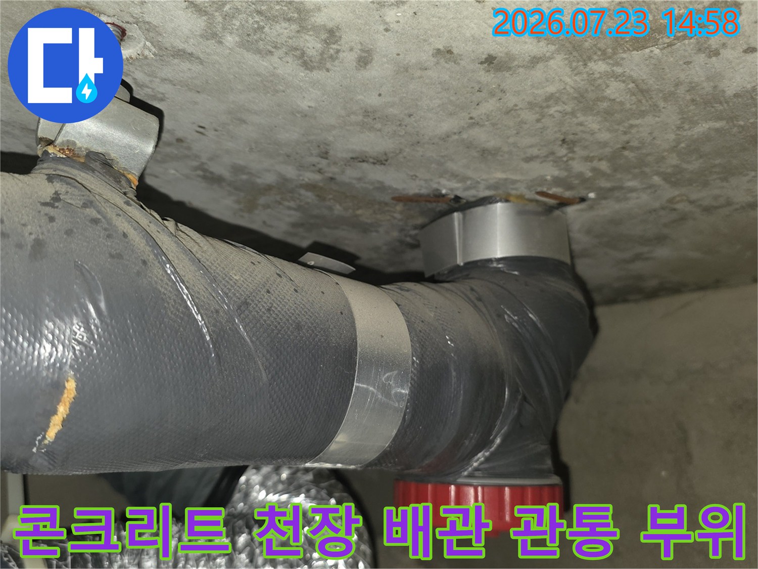 천장 콘크리트 틈새로 설치된 회색 배관-빨간색 마감재 적용 모습