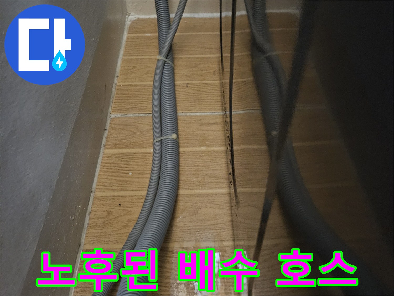 싱크대 밑 배수 파이프와 젖어있는 타일 벽면 모습