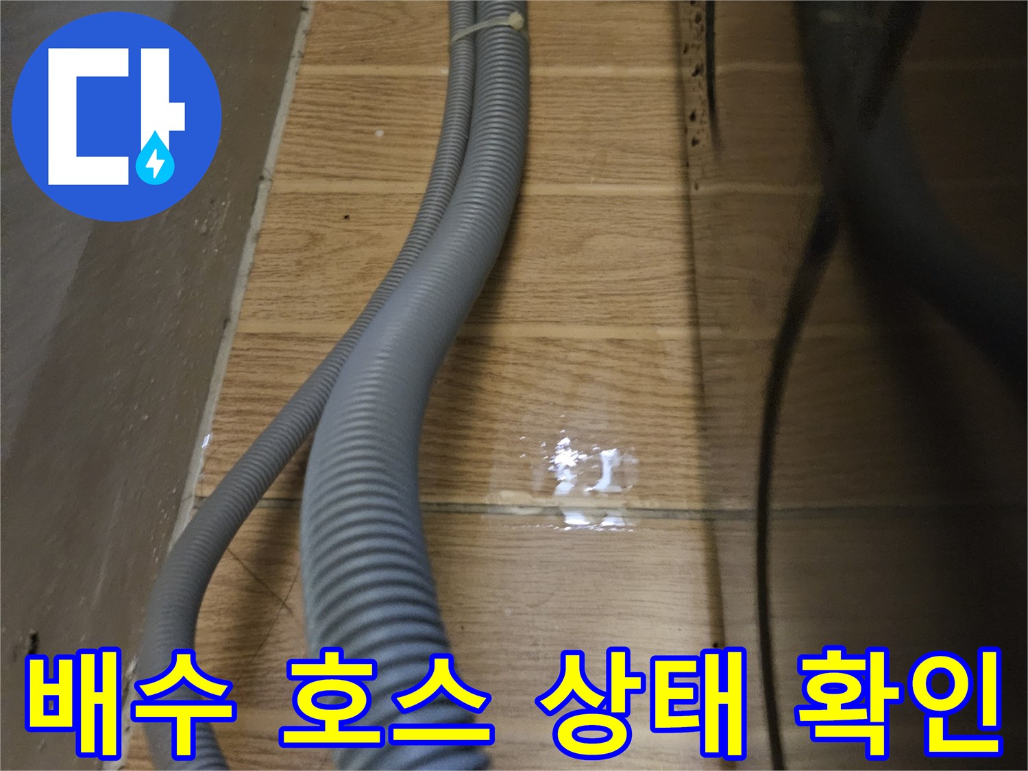 싱크대 아래쪽 회색 주름관과 젖어 있는 타일 벽면