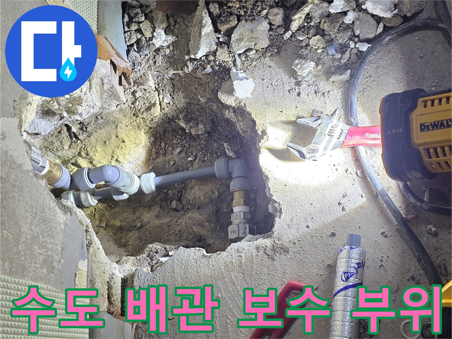 굴착된 바닥의 배관과 작업용 렌치 및 자재들