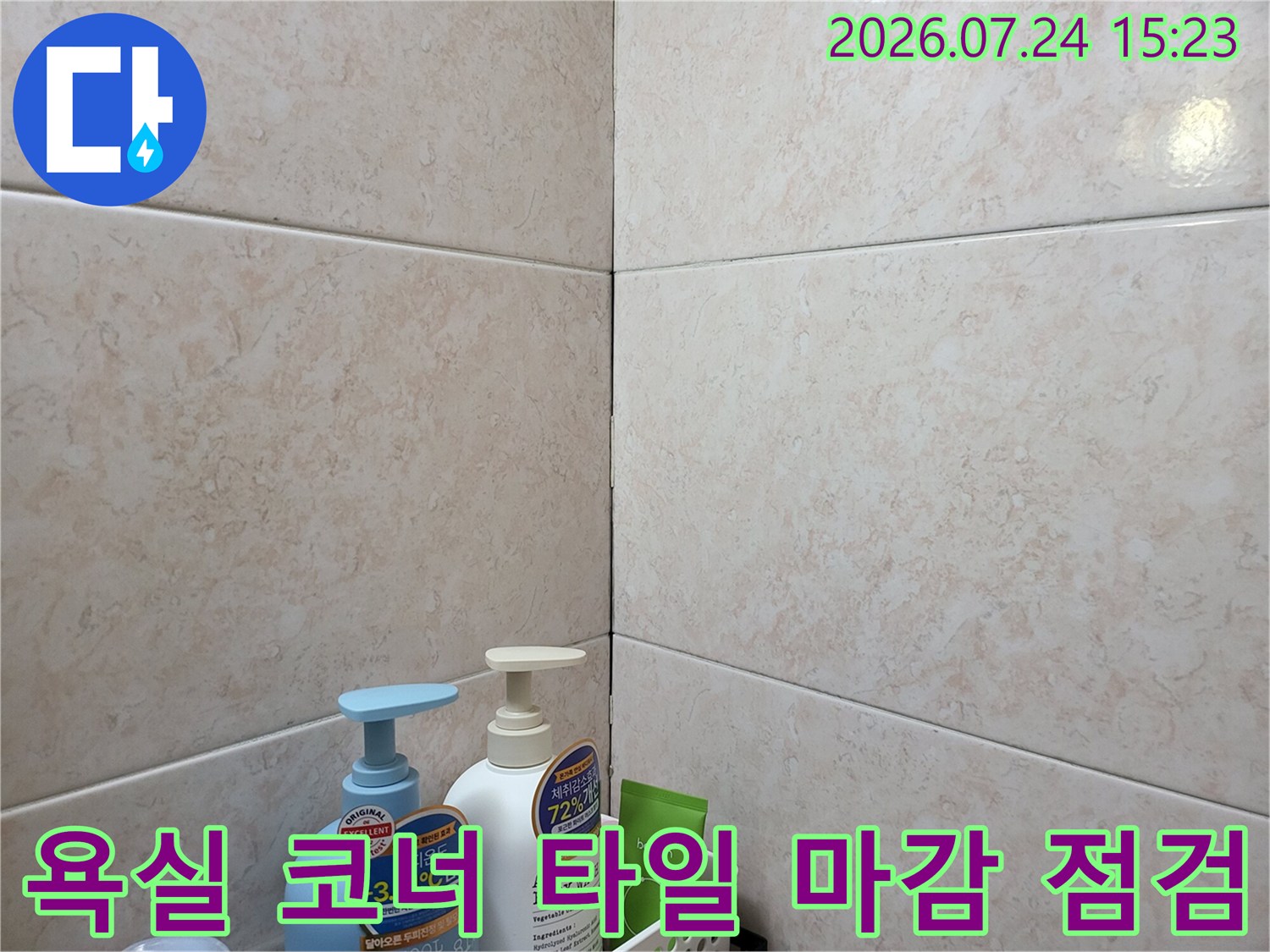 욕실 구석 모서리의 타일 접합부와 실리콘 마감 상태를 촬영한 사진